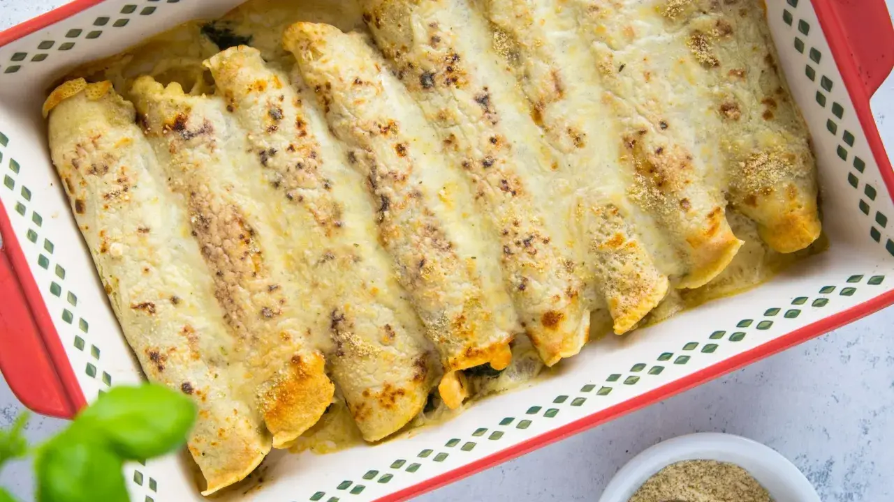 Zapiekane naleśniki z pysznym farszem, polane sosem i posypane serem, gotowe do podania.