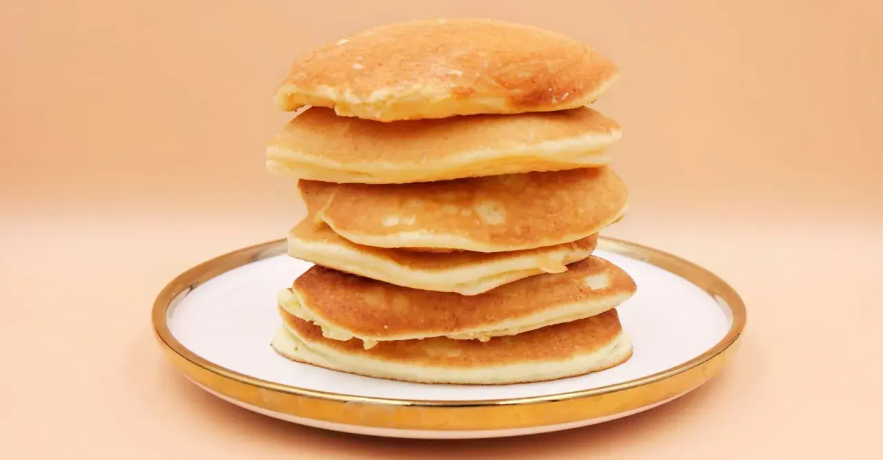 Stos puszystych, złotych pancake'ów na talerzu. Idealny przepis na śniadanie.