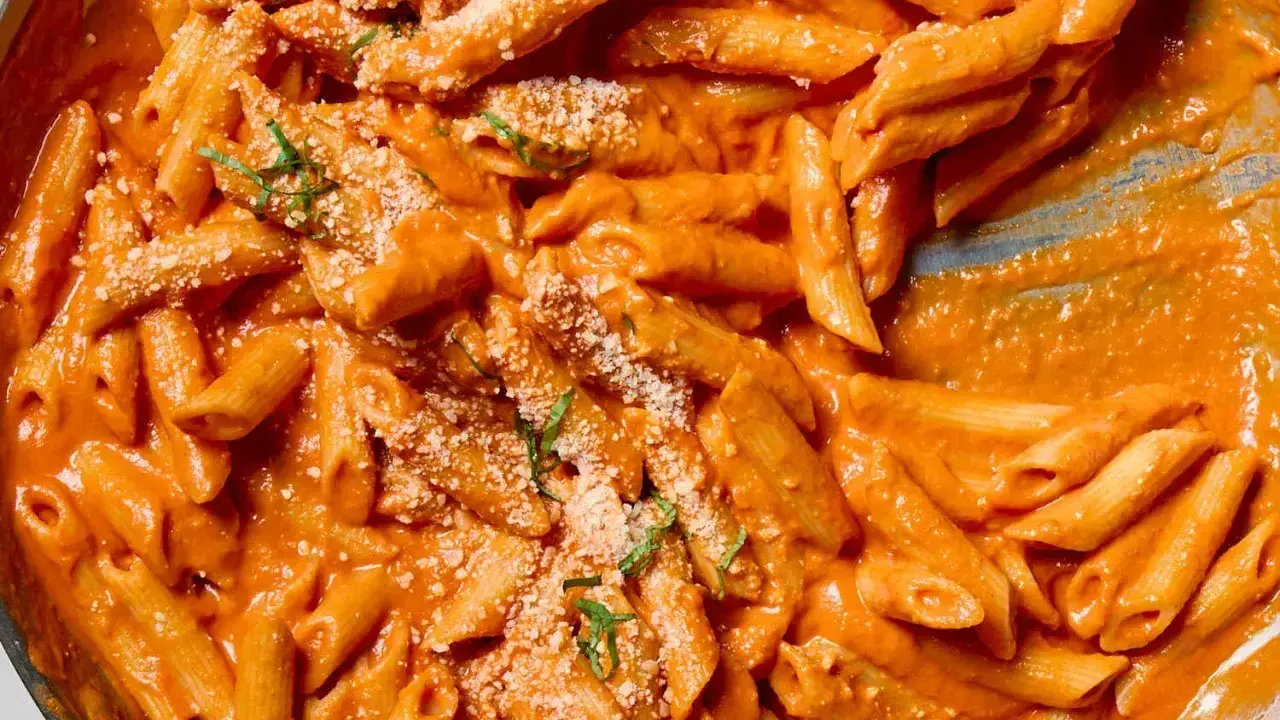 Penne alla vodka w kremowym sosie pomidorowym, posypane parmezanem i bazylią.