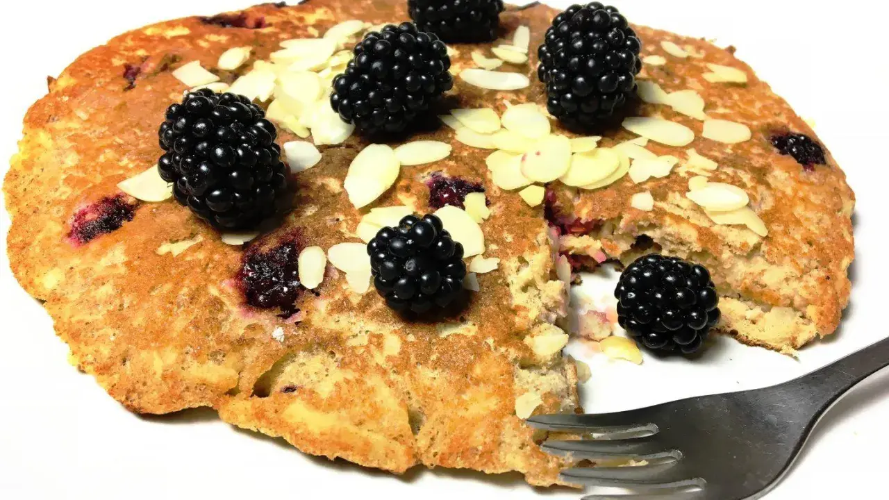 Omlet z jabłkiem i jeżynami, posypany płatkami migdałów. Pyszne śniadanie czeka na widelca.