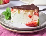 Pyszny keto sernik na zimno z kawałkami truskawek i bananów, polany czekoladą. Idealny deser dla dbających o linię.