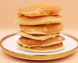 Stos puszystych, złotych pancake'ów na talerzu. Idealny przepis na śniadanie.