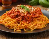 Pyszne spaghetti bolognese z mielonym mięsem, polane sosem pomidorowym i posypane serem. Idealne pytanie: jakie mięso do spaghetti?