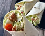 Pyszna tortilla z kurczakiem, chrupiącą sałatą i pomidorkami. Idealna na szybki lunch.