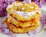 Puszyste placuszki z serka wiejskiego i banana, posypane cukrem pudrem i ozdobione bzem. Idealne na wiosenne śniadanie.