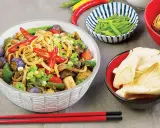 Pikantny makaron z tofu, bakłażanem, papryką i szczypiorkiem. Obok miseczki z fasolką szparagową i grzybami.