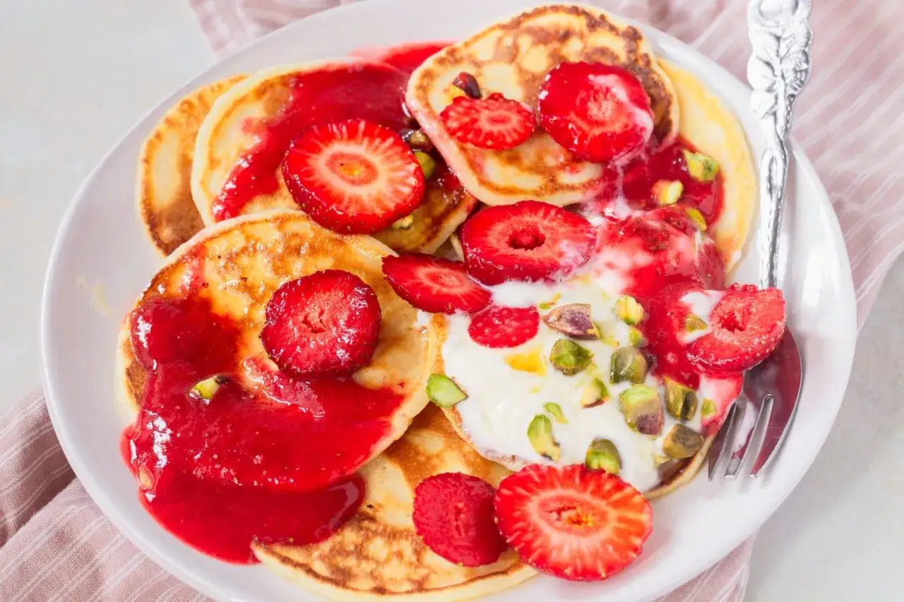 Pyszny przepis na pancake z truskawkami, jogurtem i pistacjami. Idealne na śniadanie lub deser.