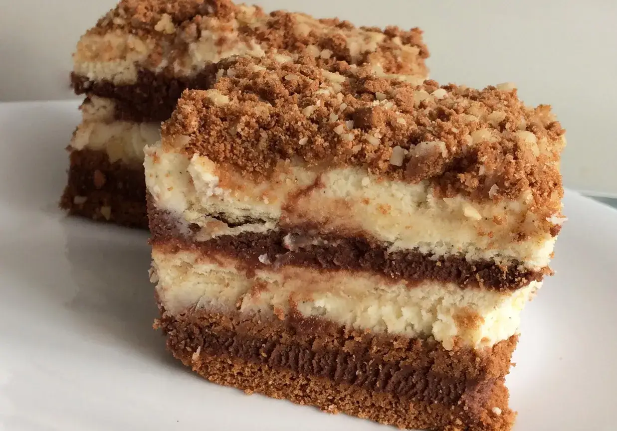 Pyszne ciasto bez pieczenia z mascarpone, przełożone warstwami czekolady i posypane kruszonką. Idealne na deser.